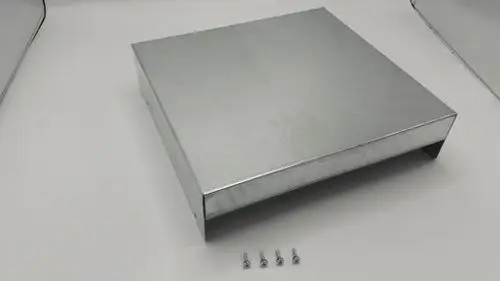 Eckiger, metallischer Deckel mit mehreren Kanten und verschraubbaren Löchern, geeignet für Regelungsgehäuse von Remeha. Sechs kleine Schrauben liegen daneben.